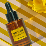 Bottle of 'The Hair Generation' hair product with a yellow label on a striped background