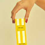 Hand holding a yellow box with 'The Hair Generation' branding on a beige background